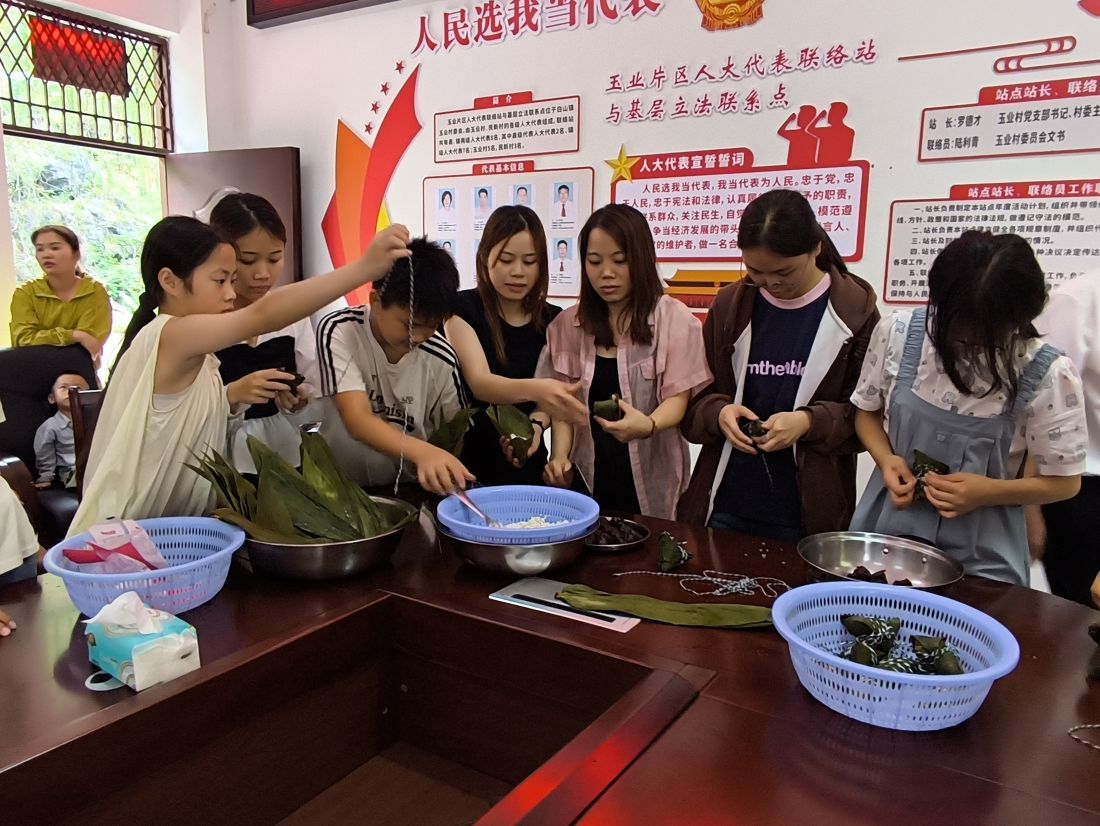 5.家长向孩子传授包粽子技巧（拍摄者韦乐）.jpg