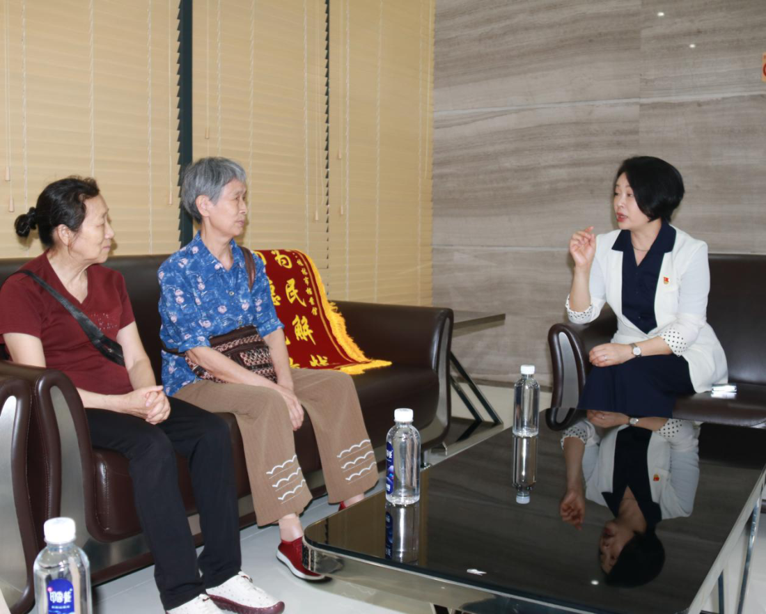 桂林市档案馆馆长李南海（右一）与钢铁厂老职工交谈.png